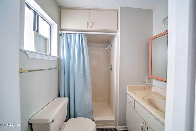 bathroom featuring a shower with curtain, vanity, toilet, and a textured ceiling