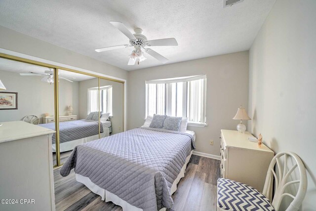 bedroom featuring ceiling fan, a textured ceiling, a closet, and dark hardwood / wood-style flooring