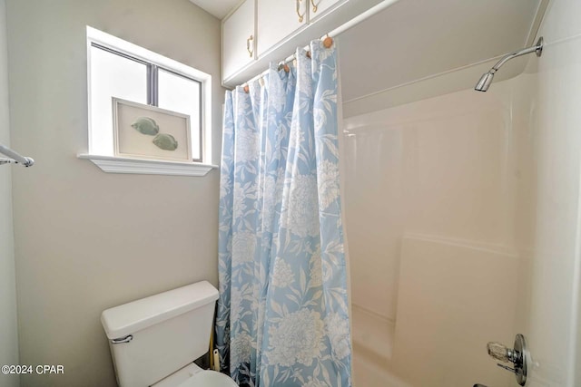 bathroom with a shower with curtain and toilet