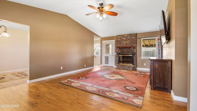 unfurnished living room featuring a fireplace, ceiling fan, a wealth of natural light, and light hardwood / wood-style floors