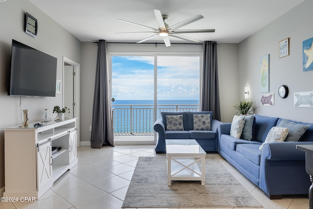 living room featuring ceiling fan, light tile patterned flooring, and a water view