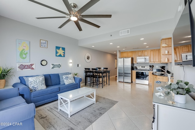 tiled living room with ceiling fan and sink