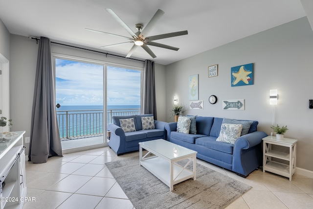 tiled living room with ceiling fan and a water view