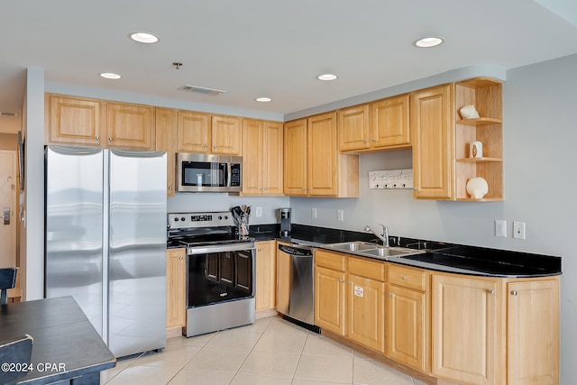 kitchen featuring light brown cabinetry, sink, light tile patterned floors, and stainless steel appliances