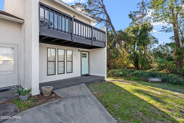 entrance to property with a balcony and a yard