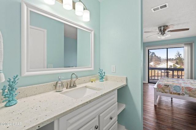 bathroom with ceiling fan, vanity, hardwood / wood-style floors, and a textured ceiling