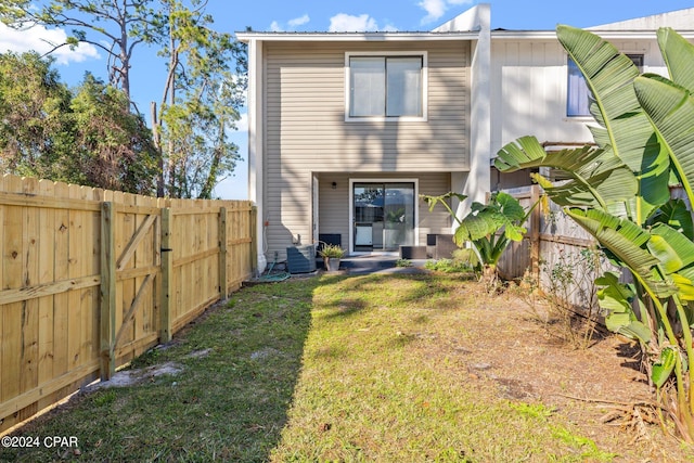 rear view of property featuring a lawn