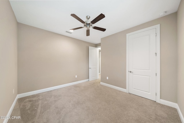 unfurnished bedroom featuring light carpet and ceiling fan