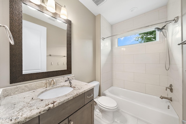 full bathroom featuring tiled shower / bath combo, vanity, and toilet