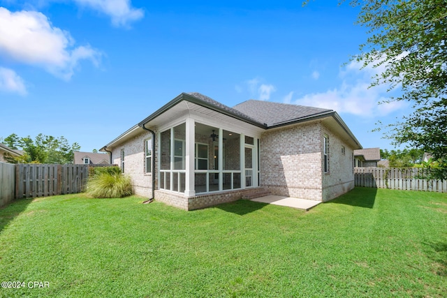 back of property featuring a yard and a sunroom