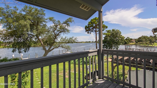 deck with a water view and a yard