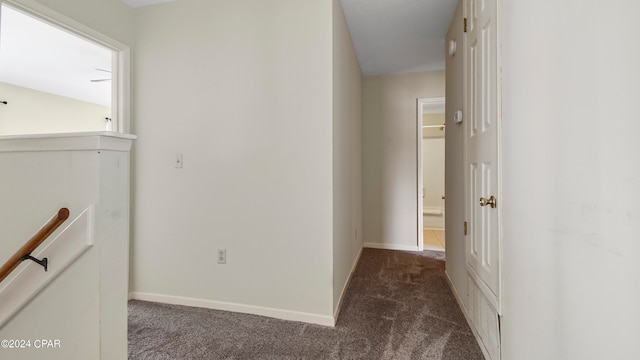 hall with dark colored carpet