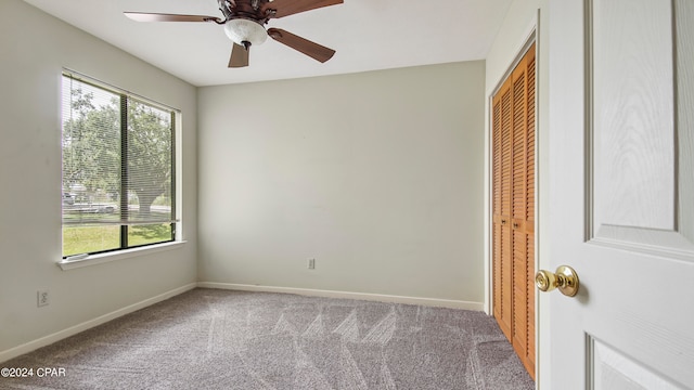 carpeted empty room featuring ceiling fan