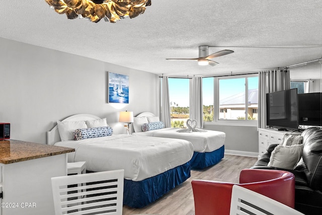 bedroom featuring ceiling fan, a textured ceiling, and light hardwood / wood-style flooring