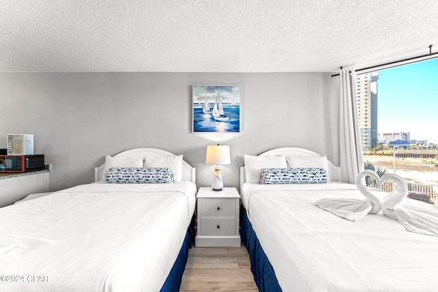 bedroom with a textured ceiling and light hardwood / wood-style flooring