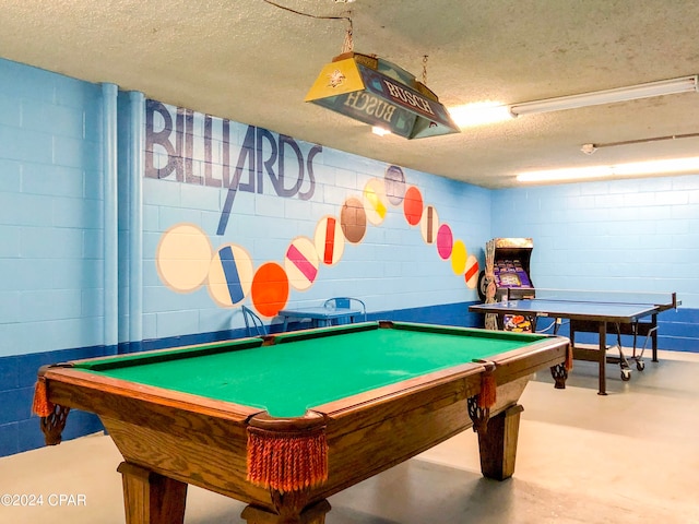 game room with a textured ceiling, concrete flooring, and pool table