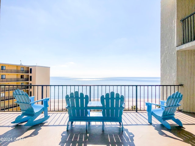 view of patio featuring a balcony and a water view