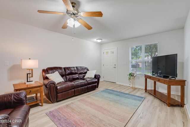 living room with light hardwood / wood-style flooring and ceiling fan