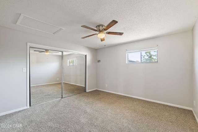 unfurnished bedroom with a textured ceiling, carpet, ceiling fan, and a closet