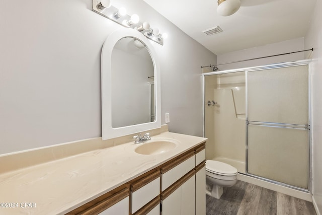 bathroom with vanity, toilet, walk in shower, and hardwood / wood-style floors