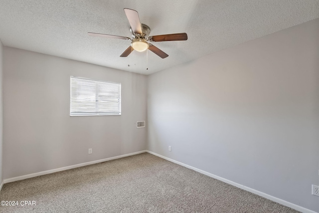 empty room featuring a textured ceiling, carpet flooring, and ceiling fan