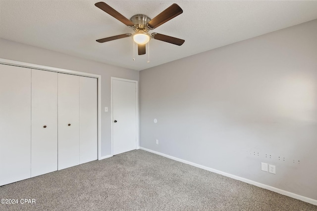 unfurnished bedroom featuring a textured ceiling, carpet floors, ceiling fan, and a closet