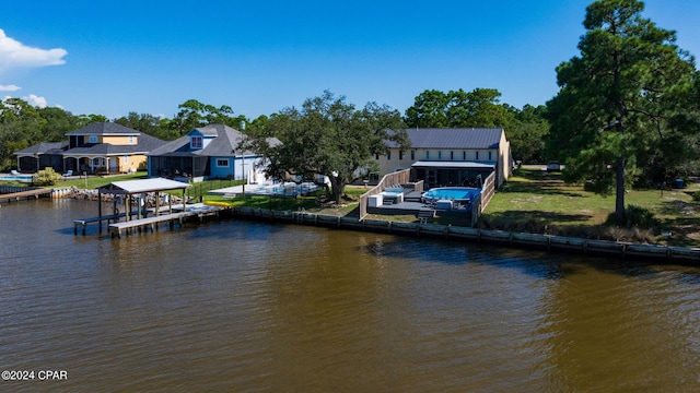 view of dock with a yard and a water view