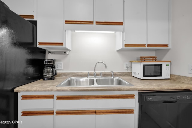 kitchen with sink, black appliances, and white cabinets