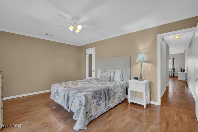 bedroom featuring ceiling fan, wood-type flooring, and ornamental molding