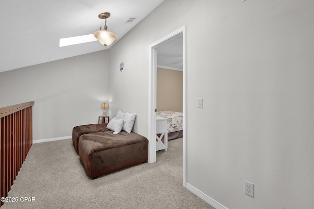 sitting room with vaulted ceiling with skylight and light colored carpet