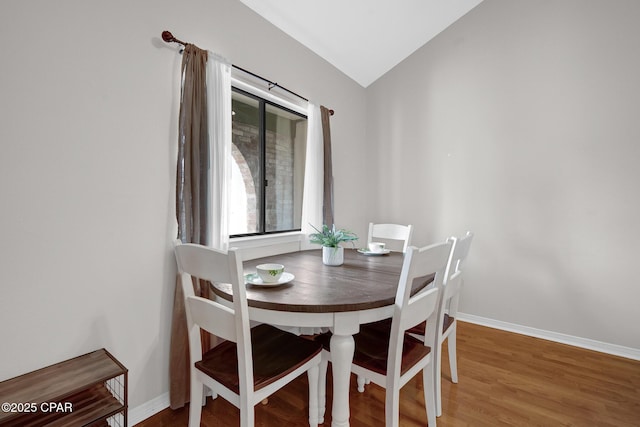 dining space with lofted ceiling and wood-type flooring