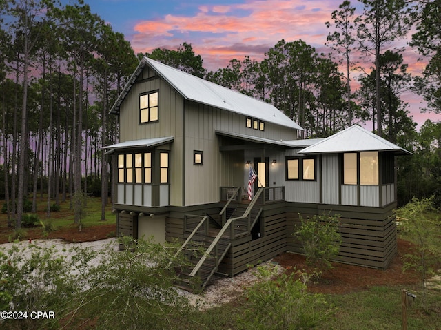view of front of property with stairway and metal roof