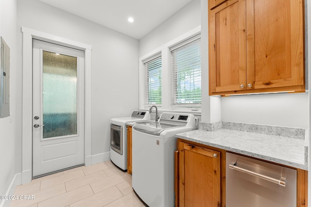 clothes washing area featuring washer and dryer, light tile patterned floors, electric panel, and cabinets