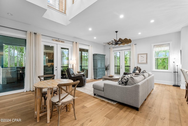 living room featuring french doors, light wood-type flooring, recessed lighting, and baseboards