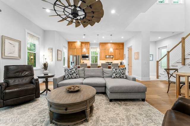 living room with a wealth of natural light, ceiling fan, and light hardwood / wood-style flooring