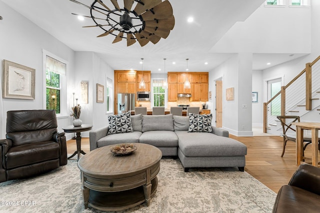 living room featuring baseboards, recessed lighting, stairway, and light wood-style floors