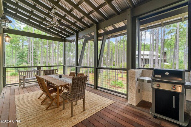 sunroom with ceiling fan and lofted ceiling