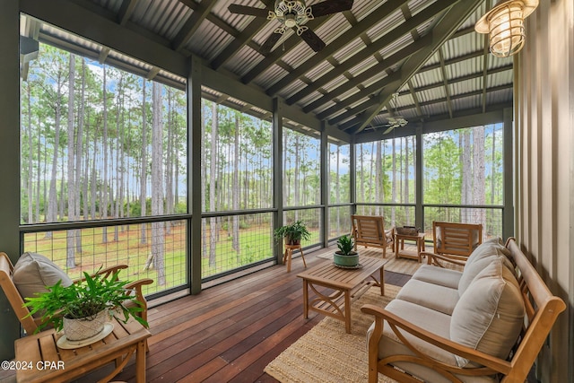 sunroom / solarium with beamed ceiling, a ceiling fan, and an outdoor living space