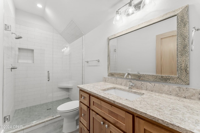 bathroom with a shower stall, toilet, vaulted ceiling, wood finished floors, and vanity