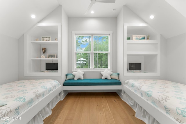 bedroom with ceiling fan, light hardwood / wood-style flooring, and vaulted ceiling