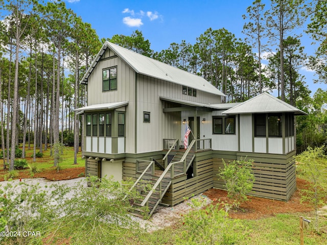 view of front of home featuring metal roof, a sunroom, and stairway