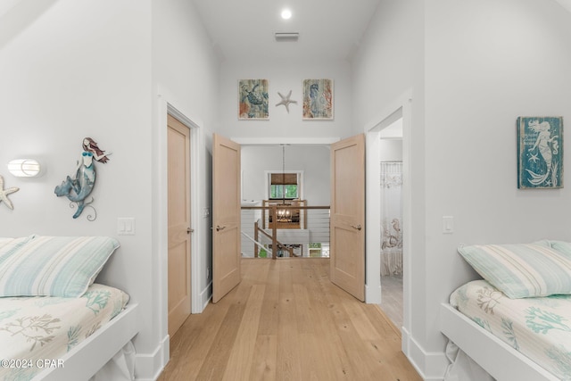 bedroom with light wood-style floors, visible vents, and baseboards