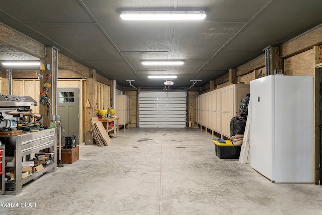 garage with a workshop area and white fridge