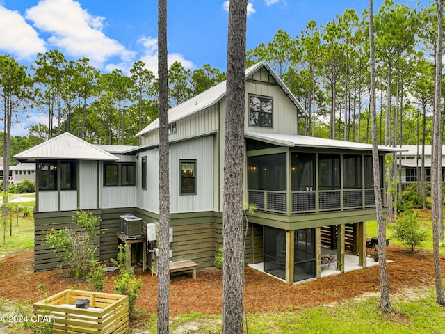 rear view of house with a sunroom, cooling unit, and a patio