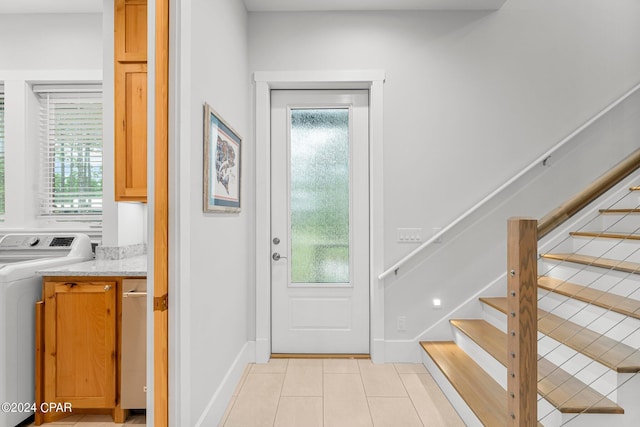 foyer with light tile patterned floors, washer / dryer, and a wealth of natural light