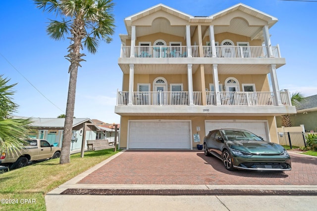 coastal inspired home with a balcony and a garage