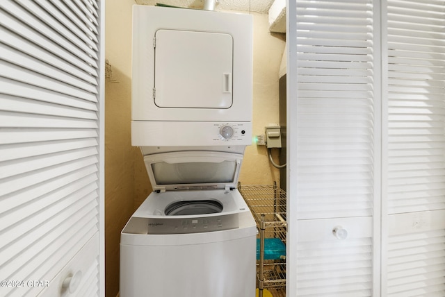 clothes washing area featuring stacked washer and clothes dryer