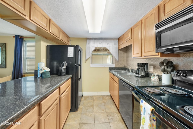 kitchen featuring black appliances, light tile patterned floors, sink, and a healthy amount of sunlight