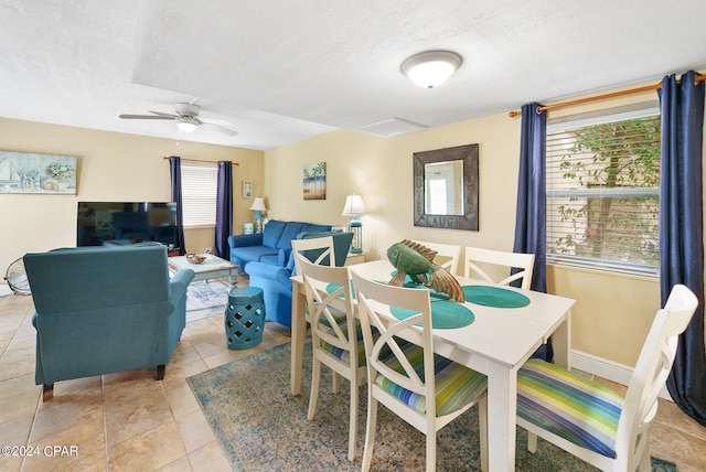 dining space featuring ceiling fan, light tile patterned floors, and a textured ceiling