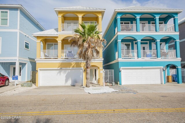 112 Riviera Dr, Panama City Beach, FL 32413 - coastal inspired home featuring a garage, stucco siding, concrete driveway, and a balcony
